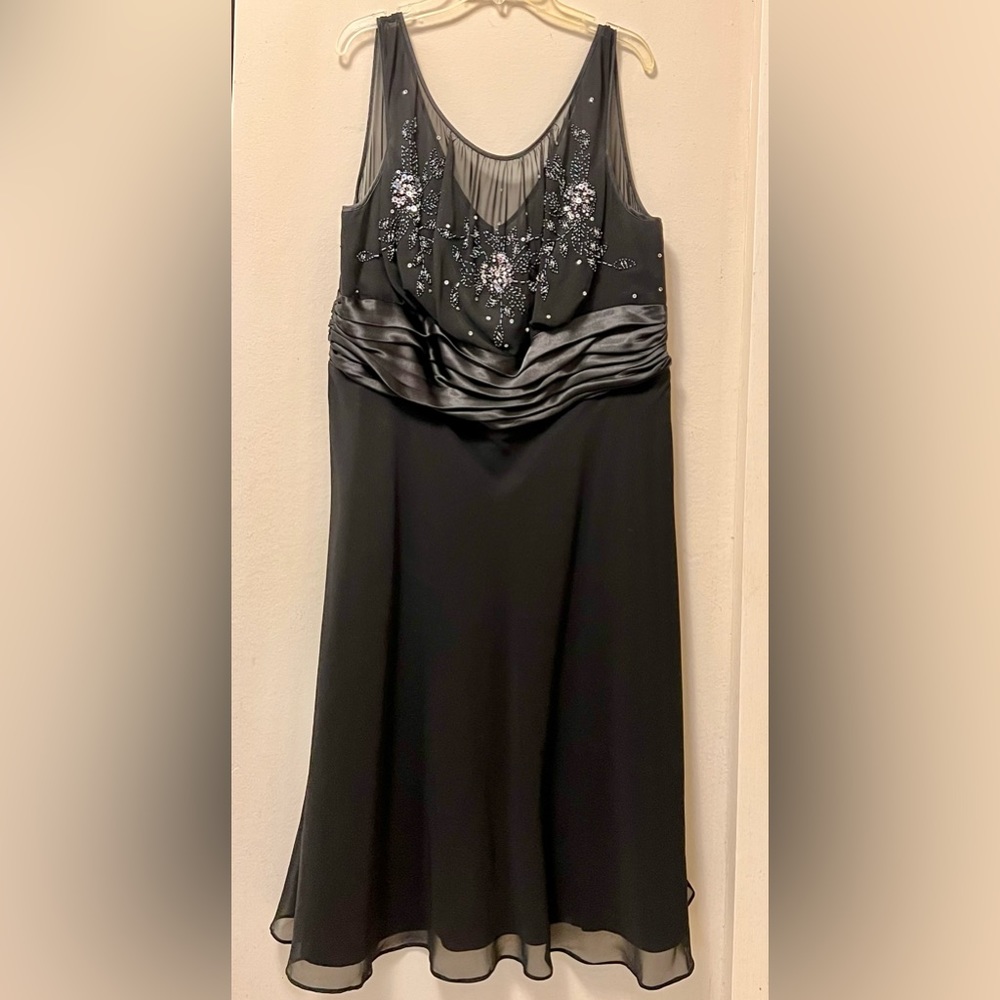 Black dress, sleeveless, draped at the waist and decorated with sequins & beads